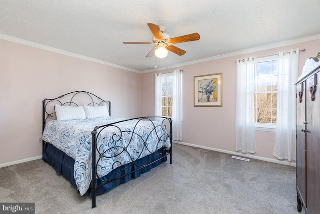 carpeted bedroom featuring ceiling fan, ornamental molding, and a textured ceiling