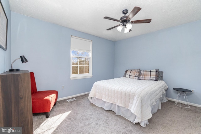 bedroom featuring light colored carpet and a textured ceiling