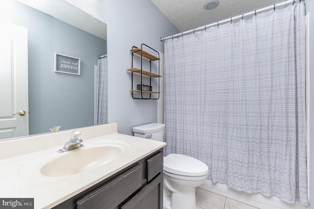 bathroom with tile patterned flooring, vanity, a textured ceiling, and toilet