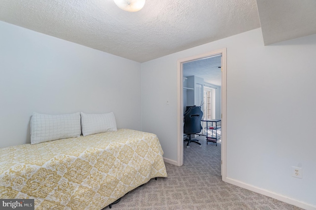 bedroom with a textured ceiling and carpet flooring