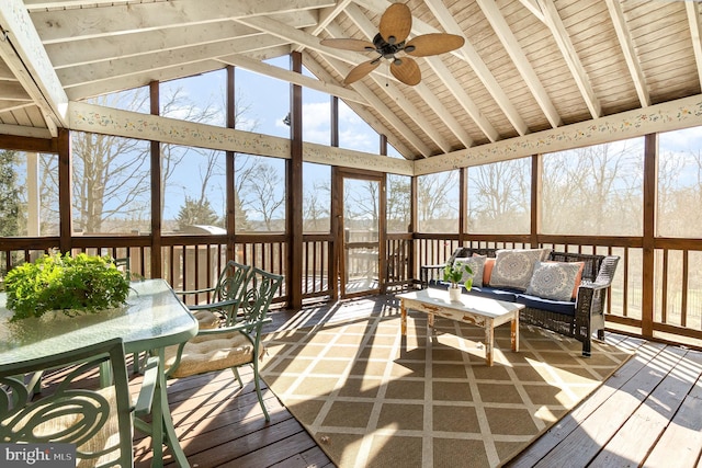 unfurnished sunroom with ceiling fan and vaulted ceiling with beams