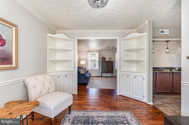 sitting room with crown molding, dark hardwood / wood-style floors, and a textured ceiling