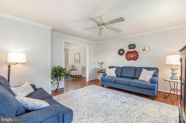 living room with crown molding, ceiling fan, dark hardwood / wood-style flooring, and a textured ceiling