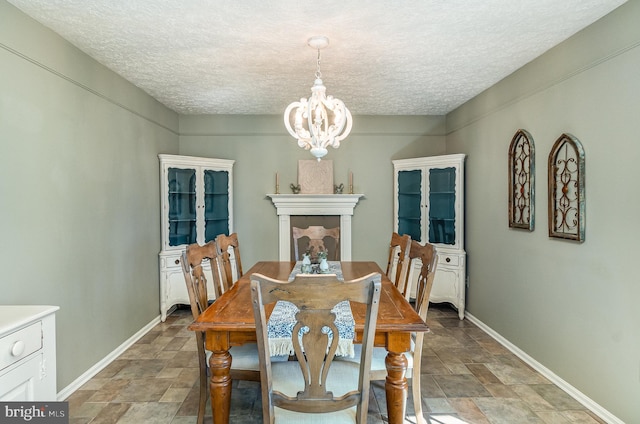 dining space with a chandelier and a textured ceiling