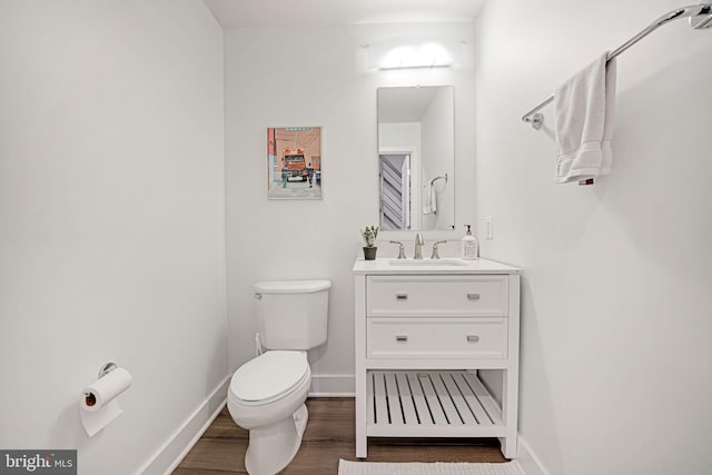 bathroom with vanity, toilet, and wood-type flooring