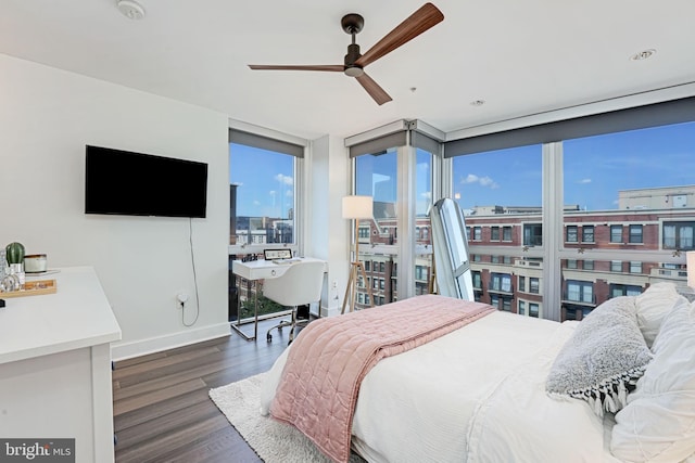 bedroom featuring dark wood-type flooring, ceiling fan, and a wall of windows