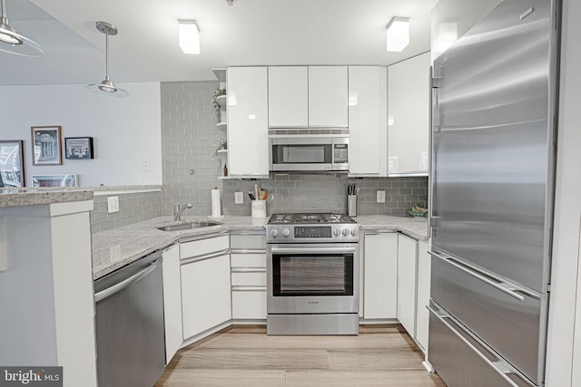 kitchen with white cabinetry, sink, decorative backsplash, and stainless steel appliances