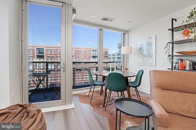 dining area featuring hardwood / wood-style floors and a wall of windows