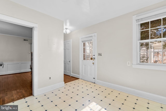 entrance foyer with plenty of natural light, baseboards, and tile patterned floors