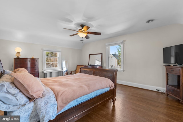 bedroom featuring ceiling fan, wood finished floors, visible vents, and baseboards