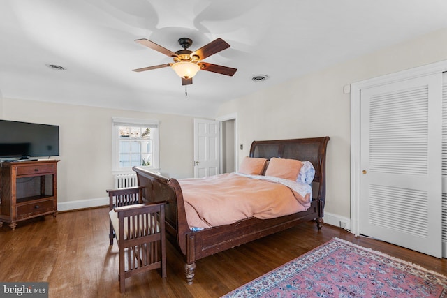 bedroom featuring a closet, wood finished floors, visible vents, and baseboards