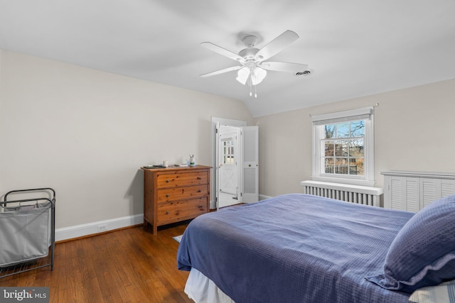 bedroom with lofted ceiling, hardwood / wood-style flooring, visible vents, a ceiling fan, and baseboards