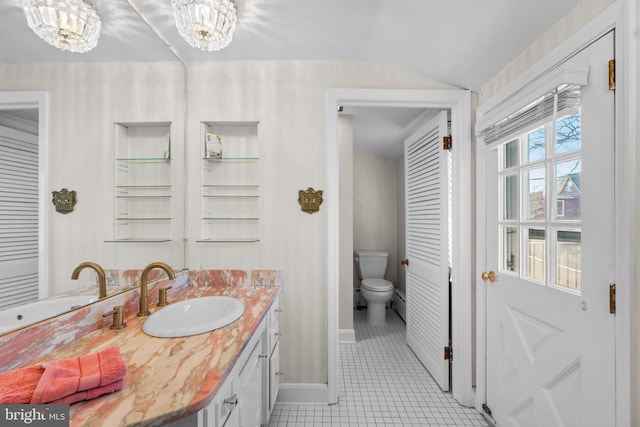 bathroom with toilet, a notable chandelier, vanity, baseboards, and tile patterned floors