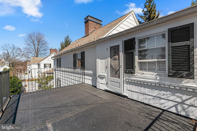 exterior space featuring a balcony and a chimney