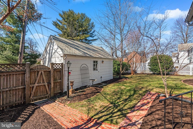 view of yard featuring an outbuilding, fence, and a gate