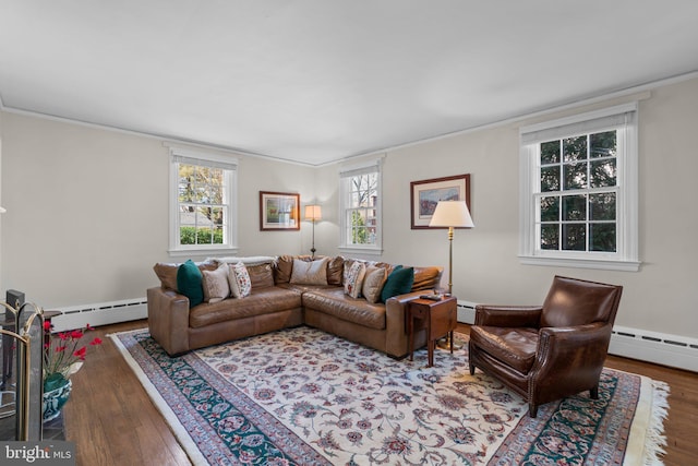 living area with wood-type flooring, a baseboard heating unit, and crown molding