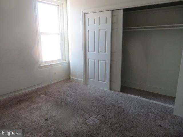 unfurnished bedroom with carpet floors and a closet