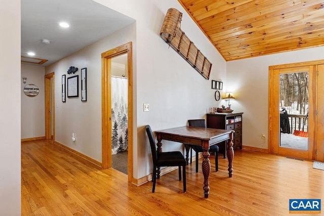 dining space featuring lofted ceiling, light hardwood / wood-style floors, and wooden ceiling