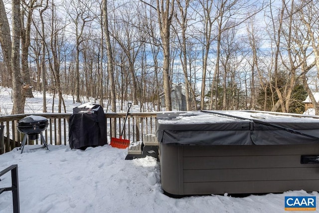 snowy yard with a wooden deck and a hot tub