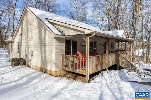 snow covered property with a porch