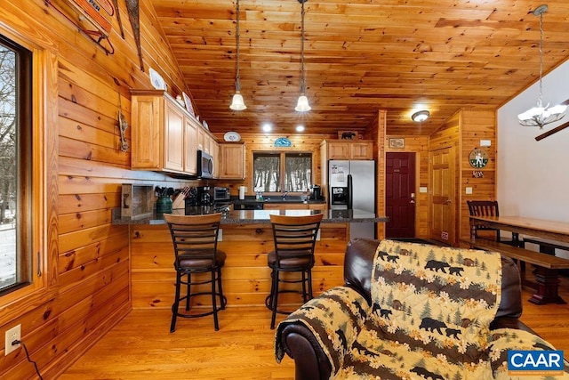 kitchen with appliances with stainless steel finishes, a wealth of natural light, light wood-type flooring, and wooden ceiling