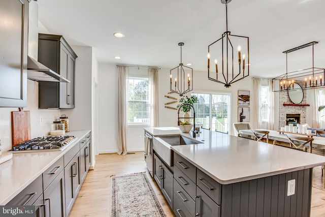 kitchen with pendant lighting, sink, stainless steel gas cooktop, and a spacious island