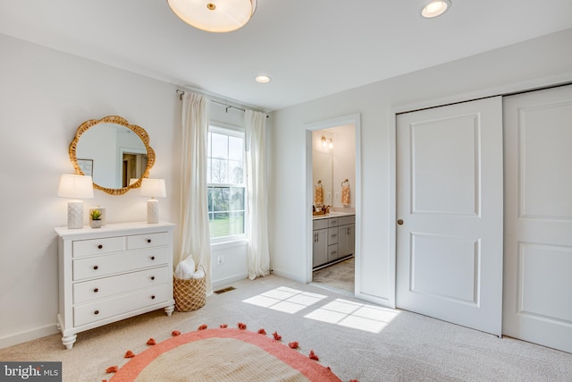 carpeted bedroom featuring connected bathroom and a closet