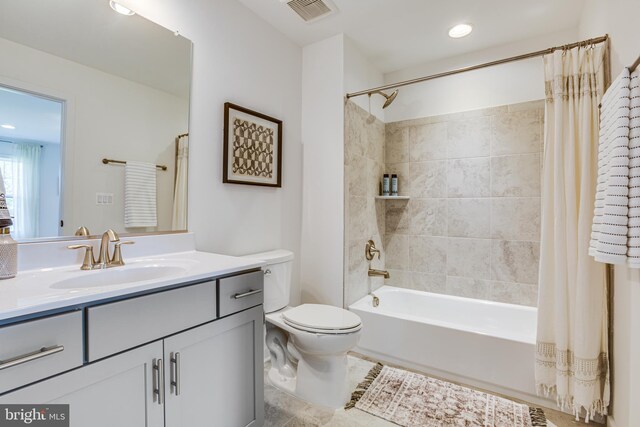full bathroom with shower / bath combo, vanity, tile patterned floors, and toilet