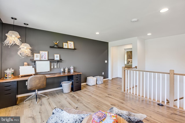 office area with built in desk and light wood-type flooring