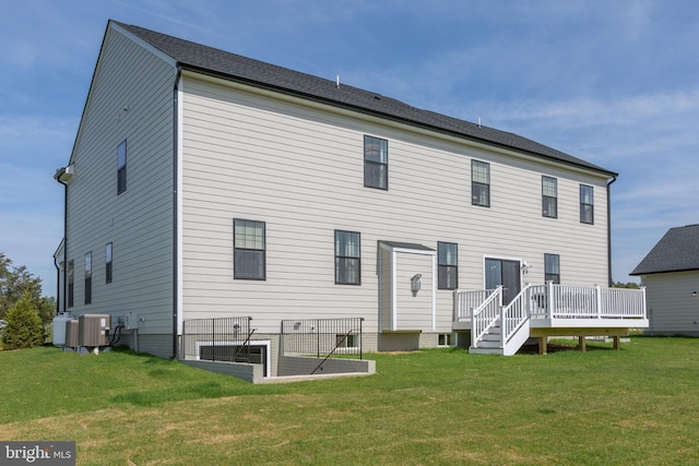 back of property with a wooden deck, central AC, and a lawn