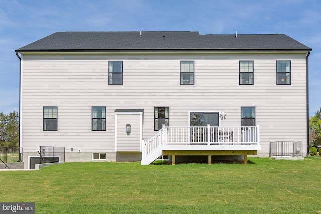 rear view of house featuring a deck and a lawn