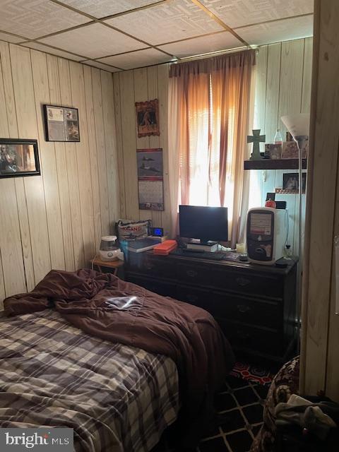 bedroom featuring wood walls