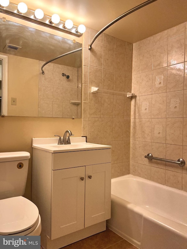 full bathroom featuring tiled shower / bath combo, vanity, tile patterned flooring, and toilet