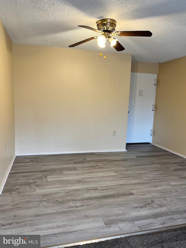 unfurnished room featuring ceiling fan, wood-type flooring, and a textured ceiling