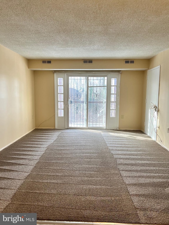 carpeted spare room with a textured ceiling