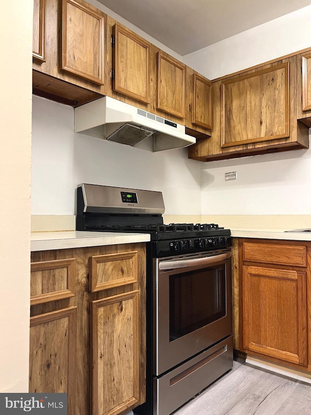 kitchen with light hardwood / wood-style flooring and stainless steel gas range oven