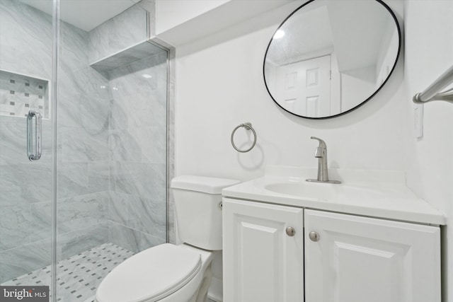 bathroom with vanity, toilet, and a shower with shower door