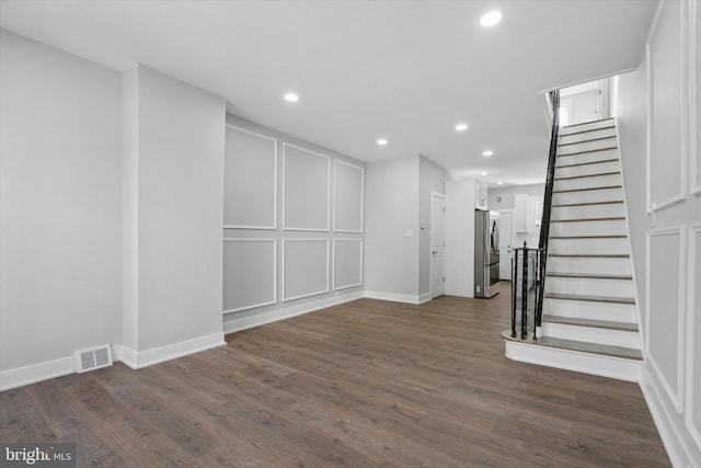 interior space with dark hardwood / wood-style floors and stainless steel fridge