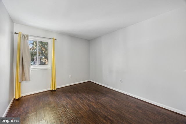 unfurnished room with dark hardwood / wood-style flooring