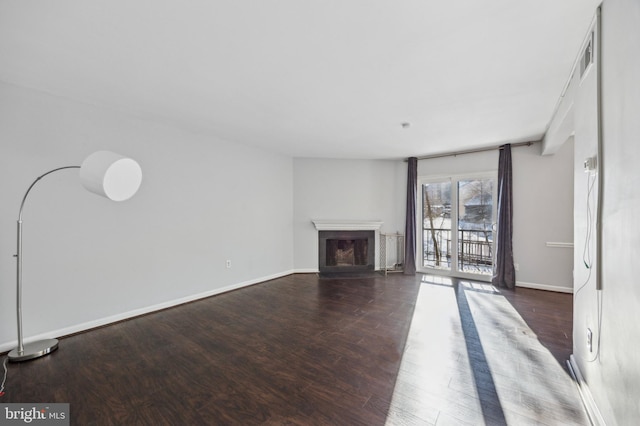 unfurnished living room with dark wood-type flooring