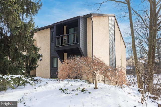 view of snow covered exterior with a balcony