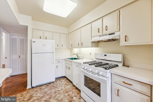 kitchen with white appliances, sink, and white cabinets