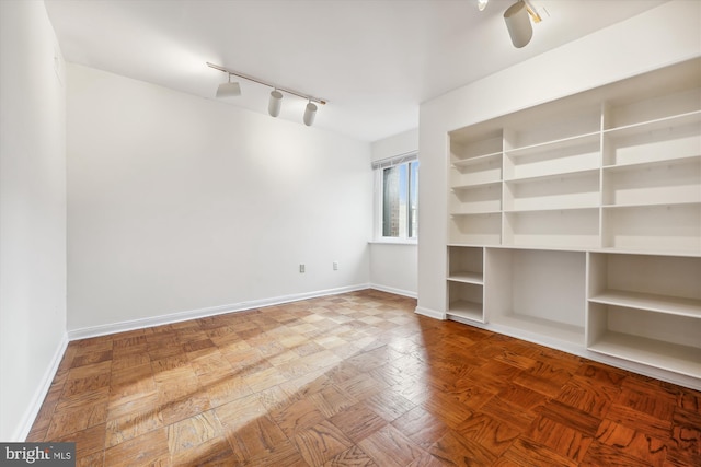 spare room with parquet floors and track lighting