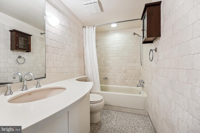 full bathroom featuring shower / bath combo, tile walls, vanity, and toilet