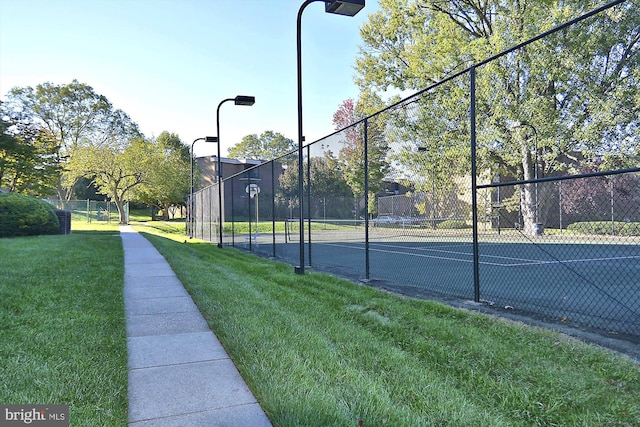 view of sport court featuring a lawn