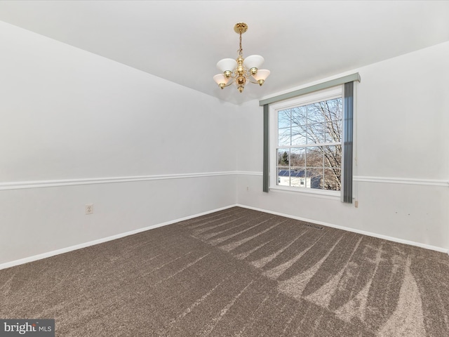 carpeted empty room featuring a notable chandelier