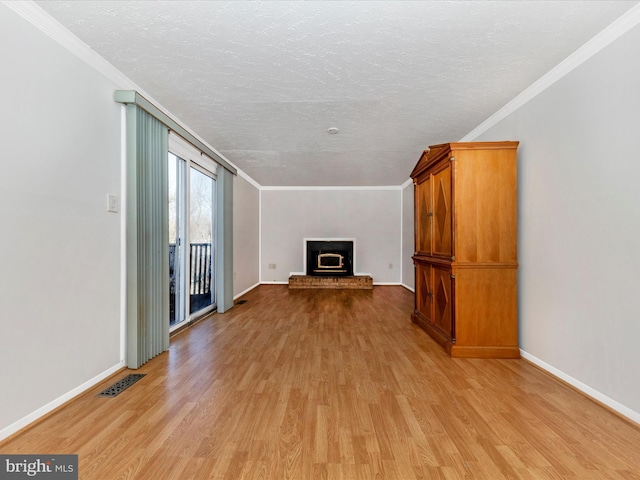 unfurnished living room featuring ornamental molding, a fireplace, and light hardwood / wood-style floors