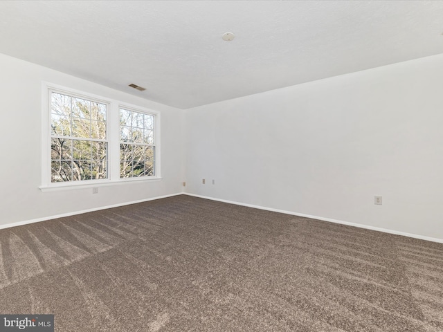 carpeted empty room with a textured ceiling