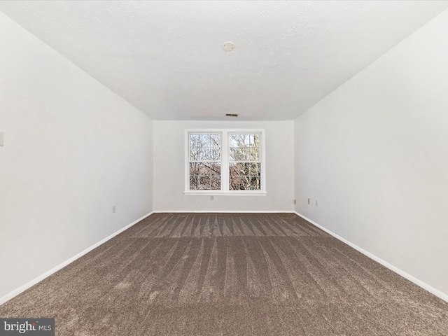 carpeted spare room featuring a textured ceiling