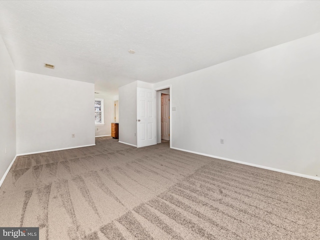 spare room with carpet and a textured ceiling